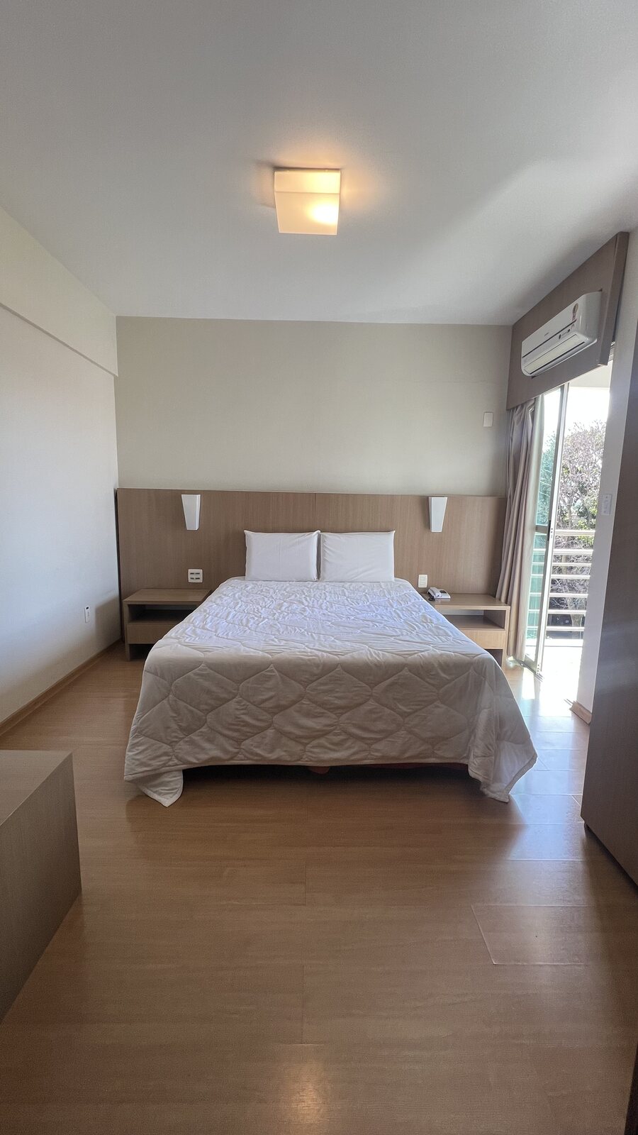 Quarto para casal do Residence Hotel com cama de casal, ar-condicionado e armário